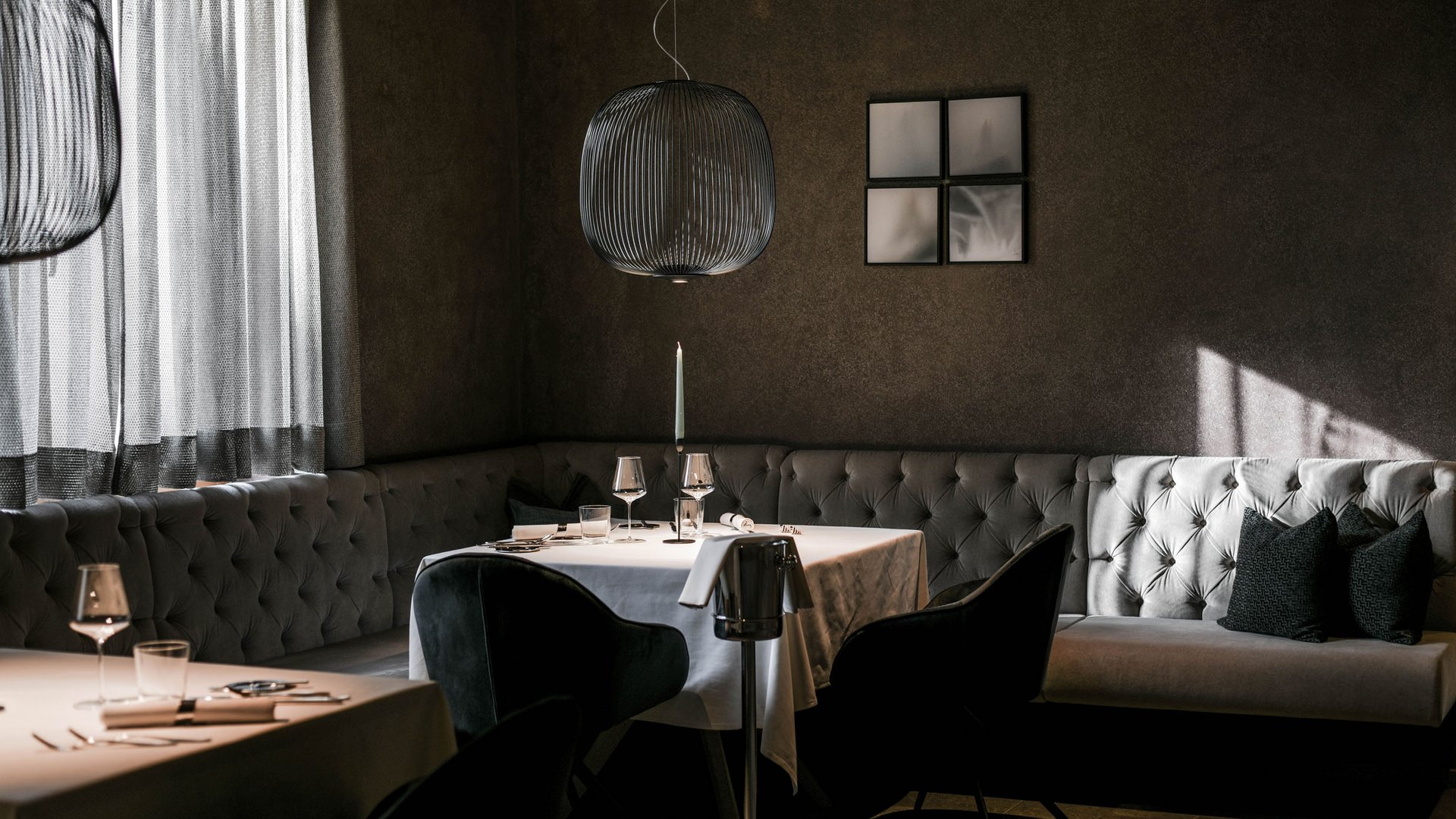 4-Sterne-Hotel Lamm am Fuße der Seiser Alm Eleganter Restaurantbereich mit gedämpfter Beleuchtung und modernem Interieur