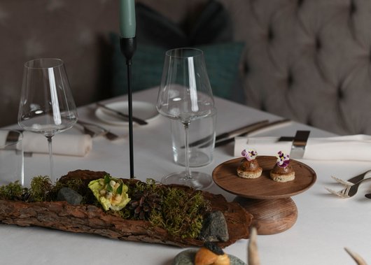 Gourmet restaurant in South Tyrol: Lampl Stube Elegant table setting with candle, glasses, and artistic appetizers