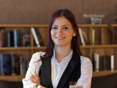 4-Sterne-Hotel Lamm am Fuße der Seiser Alm Junge Kellnerin im Restaurant mit verschränkten Armen und freundlichem Lächeln